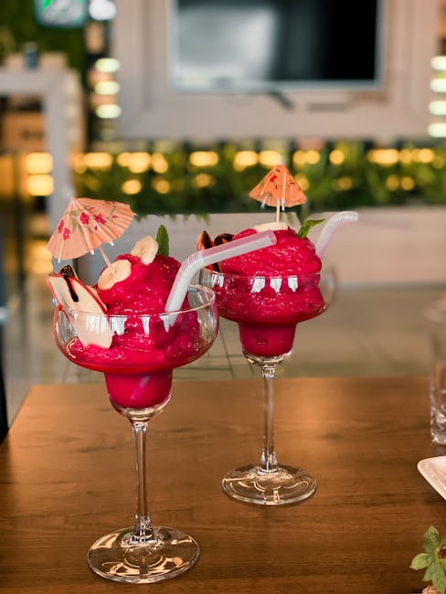 Delicious raspberry sorbet cocktails with umbrellas on a restaurant table, perfect for a refreshing treat.