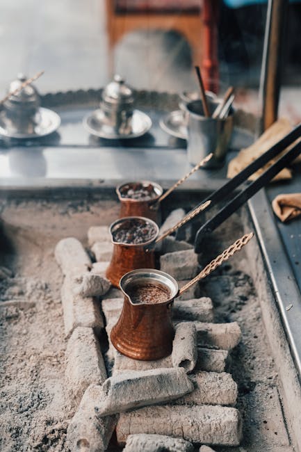 Close-up of Turkish coffee being brewed using cezves on hot ash in Istanbul's traditional style.
