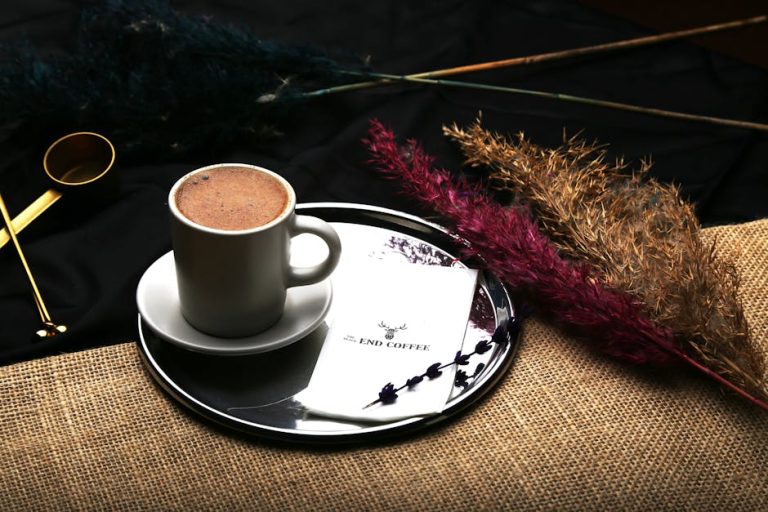 Stylish coffee cup on a tray with dried plants and rustic decor, perfect for a cozy beverage scene.