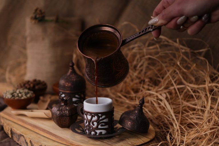 A hand pouring traditional Turkish coffee into a cup with ornate designs in an İstanbul setting.