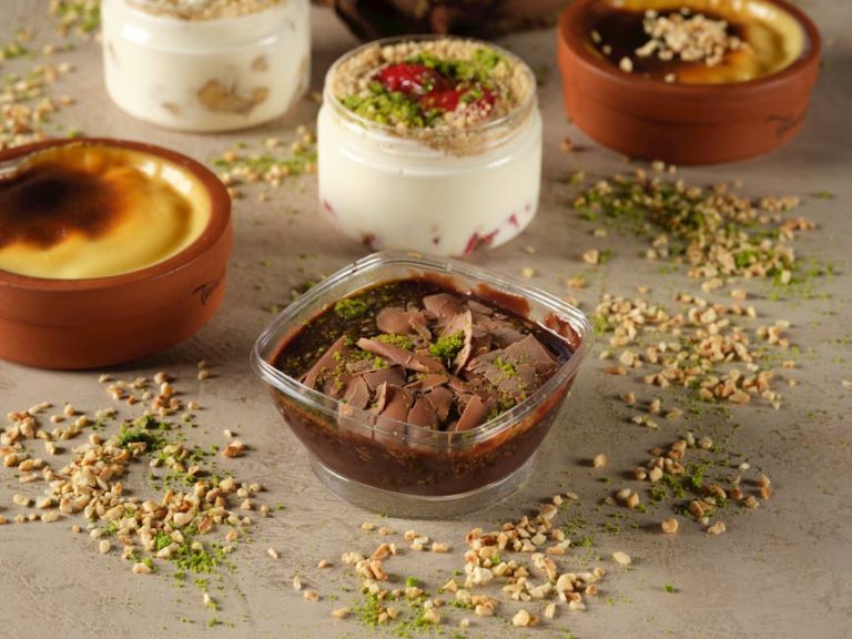 A selection of mouth-watering desserts including chocolate pudding and yogurt with nuts artfully arranged.