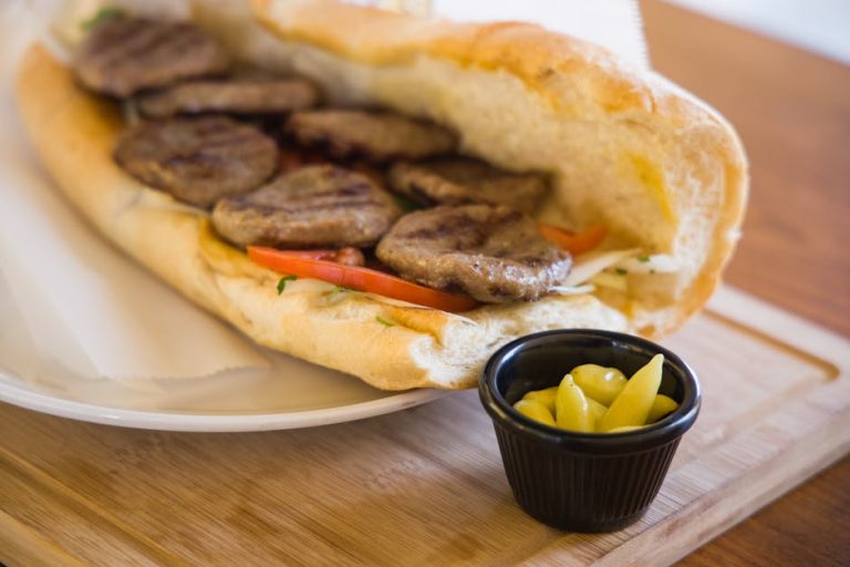 Delicious grilled patty sandwich served with peppers, perfect for a tasty meal.