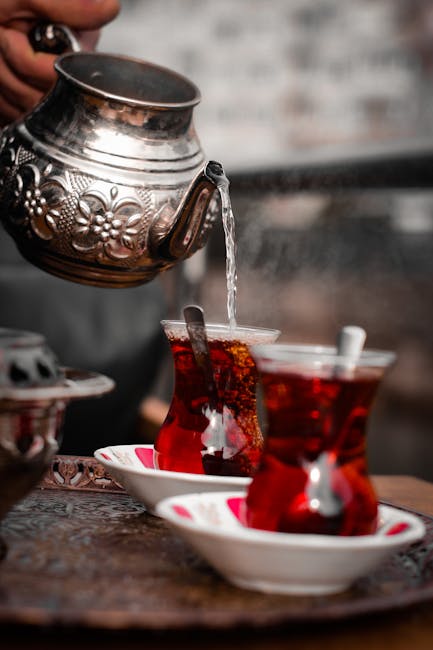 Close-up of traditional Turkish tea being served in ornate glasses, a cultural staple.